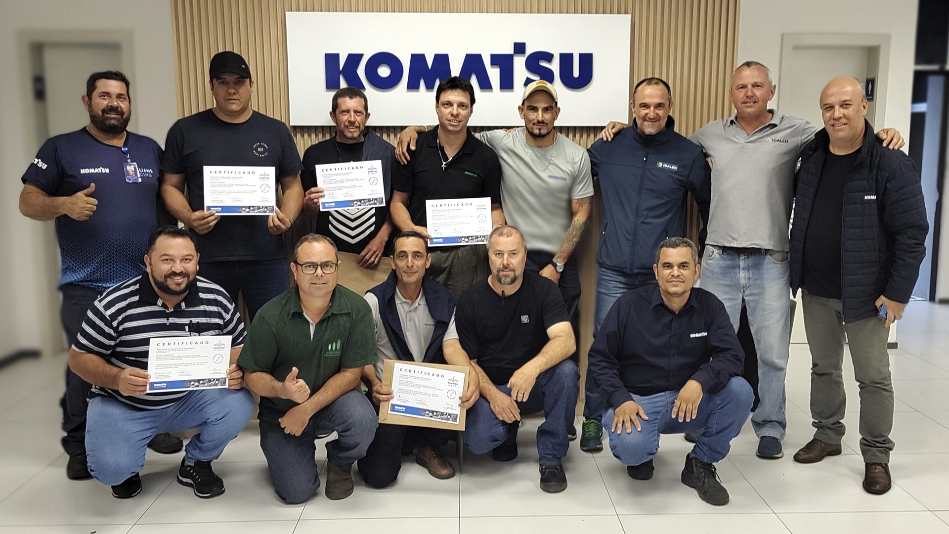 Turma de alunos da Komatsu School com os certificados de conclusão do treinamento